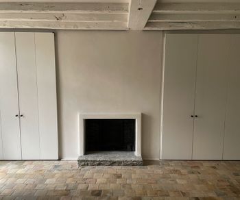 fireplace, stucco walls and limepainted ceiling beams